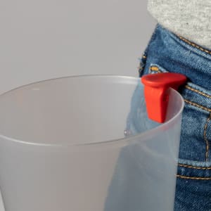 A clear plastic cup with a red clip, designed for easy attachment to pockets or bags.