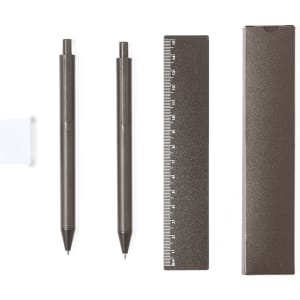 A brown writing set featuring two pens, a ruler, and a slim storage case. The case has a branding logo.