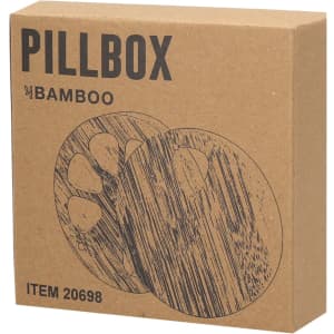 A bamboo pillbox in a brown cardboard box, featuring a simple design with a paw print pattern.