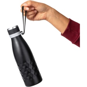 A drink bottle with a black, geometric design, held by a hand with a strap at the top. It has a metallic lid and branding.