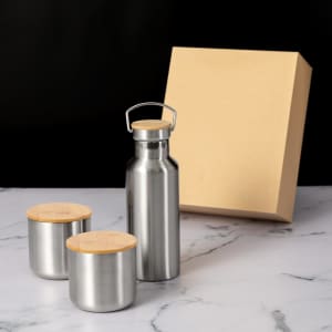 A drink bottle and two cups with wooden lids, all in stainless steel, presented with a beige box.
