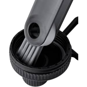 A drink bottle with a black cap and a grey cleaner brush inserted, featuring fine bristles for cleaning.