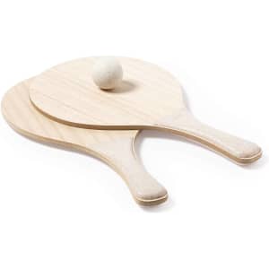 Two wooden beach rackets in light colour with a white ball resting on top. The product includes a logo.