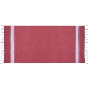 A red towel pareo with white stripes and tassels along the edges. Features branding. Perfect for leisure and outdoor use.