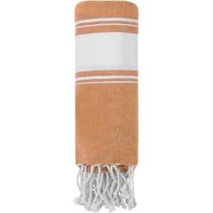A towel pareo in orange with white stripes and tassels at the ends. It has a logo printed on the fabric.