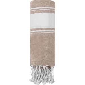 A beige and white towel pareo with fringed edges and stripes, featuring a logo.