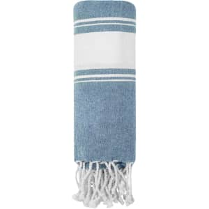 A rolled blue and white towel pareo with fringe edges and a simple stripe pattern. It features a branding logo.