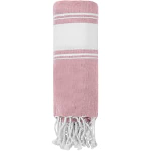 A pink and white towel pareo with fringe detailing, featuring a simple striped design and a logo.