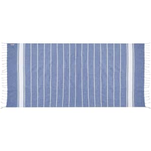 A blue and white striped towel with fringed edges, designed for beach or home use, featuring a small logo.