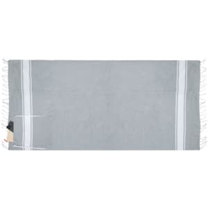A light grey drawstring bag pareo with white stripes and tassels, featuring a small tag and a logo.