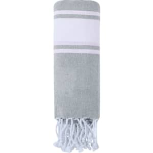 A grey and white drawstring bag pareo with fringed edges and a simple striped design. It has a logo.