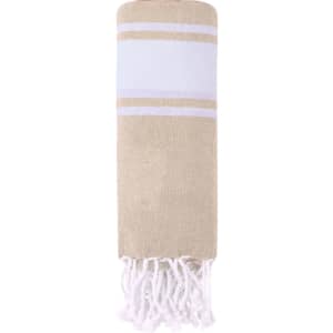 A beige and white drawstring bag made of textured fabric, featuring tassels and a logo.