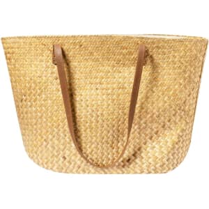 A woven straw tote bag with brown leather straps, showcasing a natural, earthy tone.