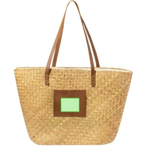 A natural straw tote bag with brown leather straps and a square green accent on the front.
