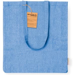 A blue tote bag made from recycled cotton, featuring a tag with information about the material.