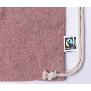 A pink Riak Fairtrade drawstring bag with a rope closure and a tag.