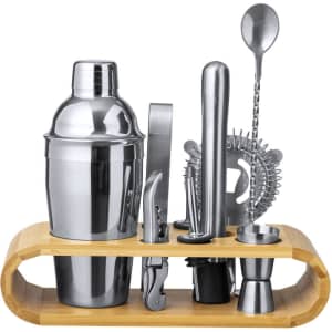 A stylish cocktail set with a stainless steel shaker, tools, and a bamboo stand, featuring sleek metallic finishes.