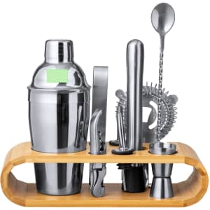 A stainless steel cocktail shaker set with a bamboo stand, including various cocktail tools and a strainer.