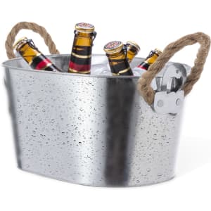 A silver ice bucket with handles, containing bottles and ice, featuring a textured finish with droplets.