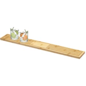 A bamboo bar runner featuring grooves, with two glasses filled with colourful drinks placed on top.