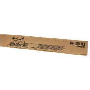 A bamboo bar runner with a slatted design, featuring two glasses on top and a logo on the packaging.