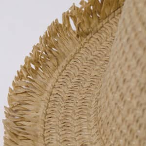 A straw hat with a wide, textured brim featuring frayed edges and a natural beige colour. It has a subtle logo detail.