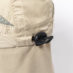 A close-up of a beige Levant Cap featuring a fastening with a black toggle. The cap has a textured design detail.