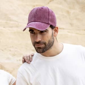 A maroon cap with a curved brim, featuring a logo, worn by a man in a light-coloured t-shirt.