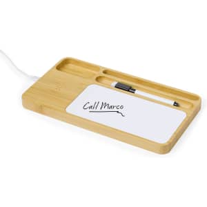 A bamboo organiser charger featuring compartments for a pen and notes, with a wireless charging pad included.