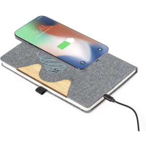 A wireless charger notepad in grey fabric with a wood interior, featuring a smartphone charging on top.