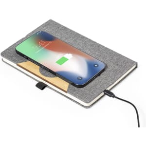 A grey notepad with a wooden accent, featuring a smartphone wirelessly charging on its surface.