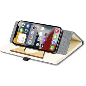 A grey notepad with a wooden phone stand, displaying a smartphone on its surface.