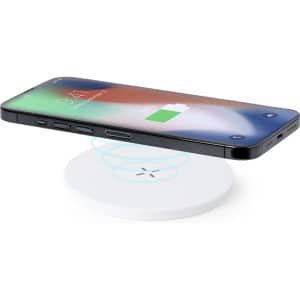A wireless charger in white with a smartphone placed on top, featuring a logo on the charging pad.