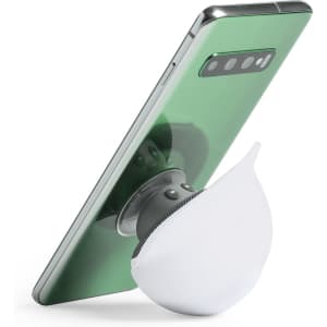 A green smartphone propped against a round, white speaker. The speaker has a curved design and a black base.