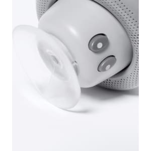 A grey portable speaker featuring buttons and a clear suction cup at the base for stability.