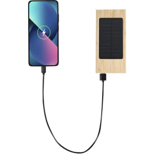 A power bank with a bamboo finish connected to a smartphone, featuring a solar panel design.