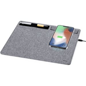 A grey wireless charger mousepad with a pen and a smartphone charging on it, featuring a logo.