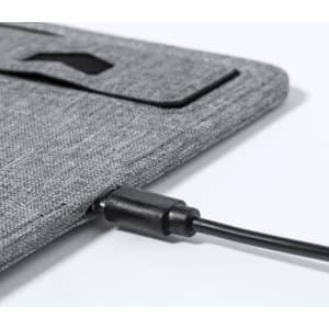 A grey charger mousepad with a textured surface and a cable connected to it. It features a branding logo.
