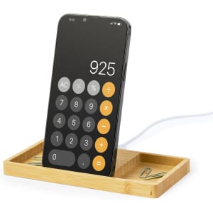 A wireless charger with a bamboo base and a smartphone displaying a calculator app. It features a compartment for accessories.