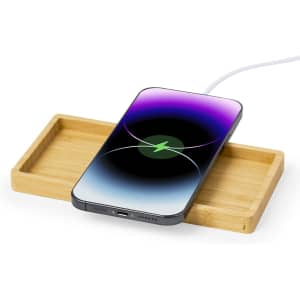 A wireless charger with a wooden base, featuring a smartphone displaying a vibrant gradient screen.
