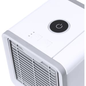 A white mini air conditioner with a power button and a gridded front panel, featuring a simple design.