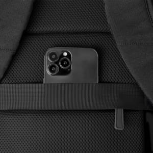 A black backpack features a smartphone secured in a mesh pocket, showcasing its organisational design.