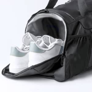 A black backpack bag with a compartment containing white and light blue sneakers. The bag has a logo.