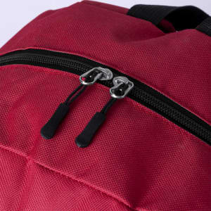 A red backpack featuring a zippered closure and black accent details. It has a logo on the surface.