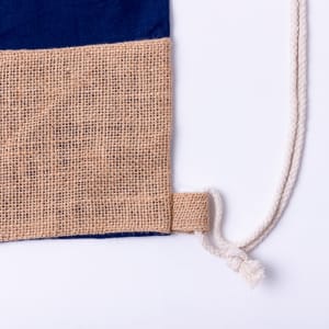 A drawstring bag featuring a navy blue fabric and a natural hessian base, with a matching drawstring.