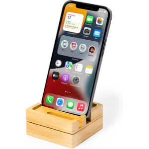 A bamboo phone stand displaying a smartphone with various app icons on the screen. The design is minimalist and light.