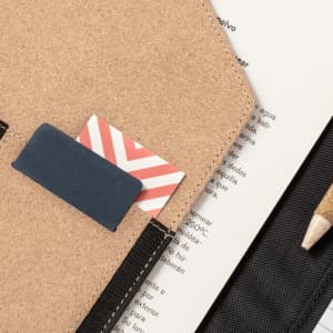 A tan Ohara Folder with card slots, a pencil, and pages visible in the background.