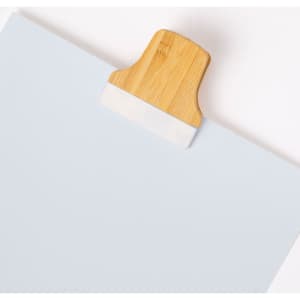 A light blue clipboard featuring a bamboo clip at the top. It has a minimalist design with a simple branding logo.