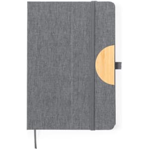 A grey notepad with a wooden accent and an elastic closure, featuring a textured cover and ribbon bookmark.