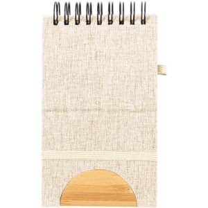 A notepad with a beige fabric cover, spiral binding, and a wooden accent at the bottom, featuring an elastic band.